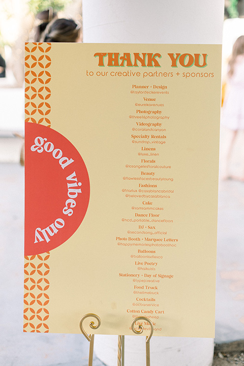  70s inspired wedding with orange and caramel tones with the bride in a lace gown and the groom in a caramel suit - menu and table numbers 