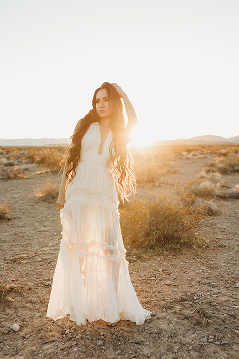  a boho elopement at the seven magical mountains in Las Vegas – the bride in a boho gown and the groom in a rose pink suit