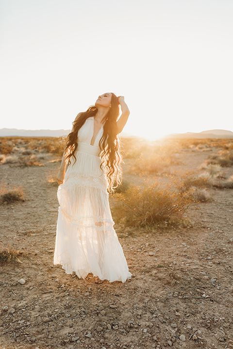  a boho elopement at the seven magical mountains in Las Vegas – the bride in a boho gown and the groom in a rose pink suit 