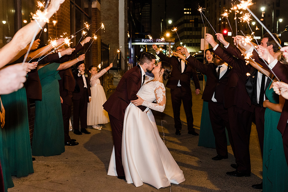  burgundy and green wedding with winter vibes - couple kissing with sparklers 