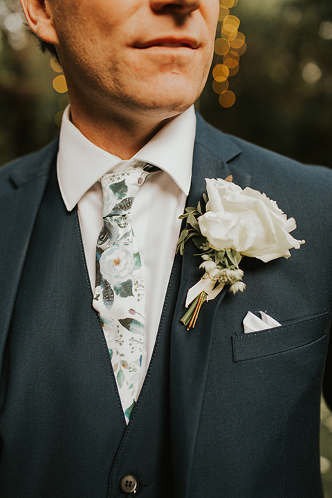  a romantic rustic garden wedding with the groom in a blue suit and floral tie and the bride in a lace gown - groom 