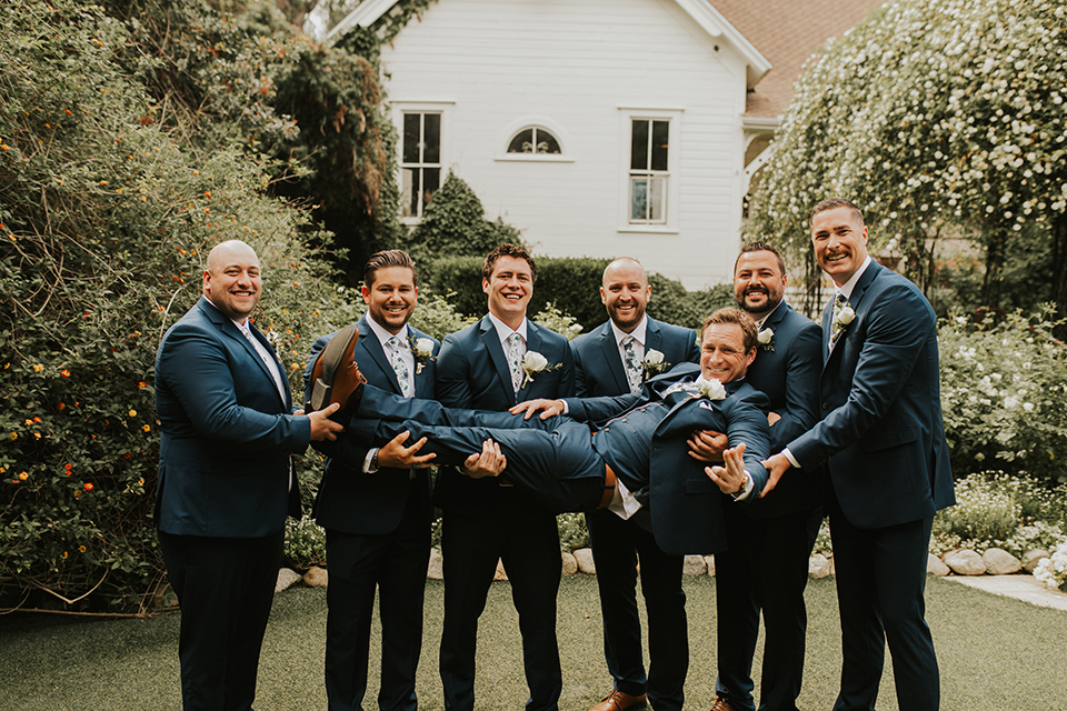  a romantic rustic garden wedding with the groom in a blue suit and floral tie and the bride in a lace gown - groomsmen 