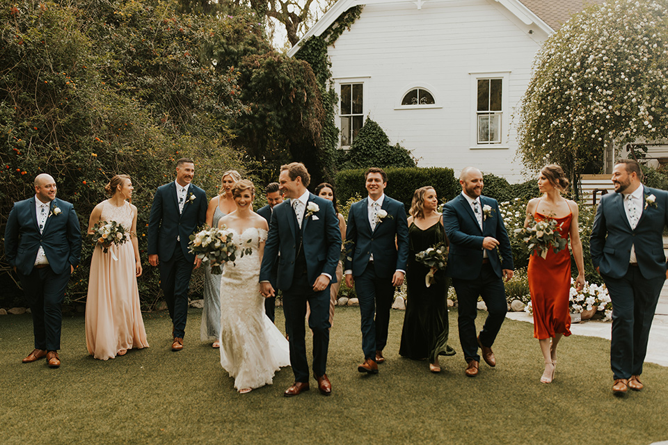  a romantic rustic garden wedding with the groom in a blue suit and floral tie and the bride in a lace gown - bridal party 
