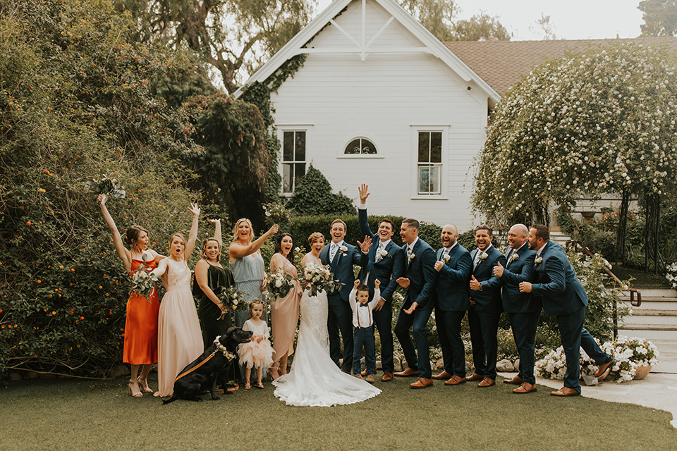  a romantic rustic garden wedding with the groom in a blue suit and floral tie and the bride in a lace gown - bridal party 