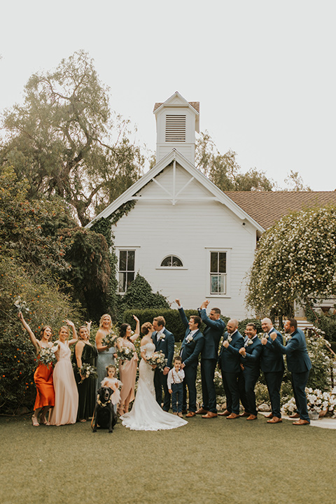  a romantic rustic garden wedding with the groom in a blue suit and floral tie and the bride in a lace gown - wedding party 