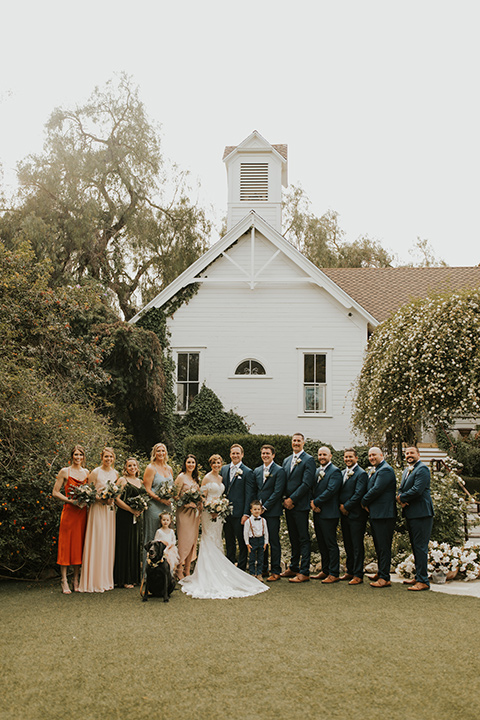  a romantic rustic garden wedding with the groom in a blue suit and floral tie and the bride in a lace gown - wedding party 