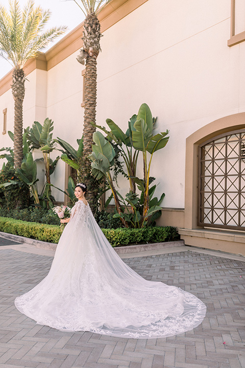  a grand cultural wedding with lion dancers and gold details – bride in a long gown with cape and groom in navy shawl tuxedo – bride in her gown 