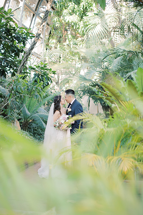  classic and modern balboa wedding with the groom in a navy shawl – couple in greenery