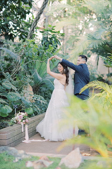  classic and modern balboa wedding with the groom in a navy shawl – couple in greenery 