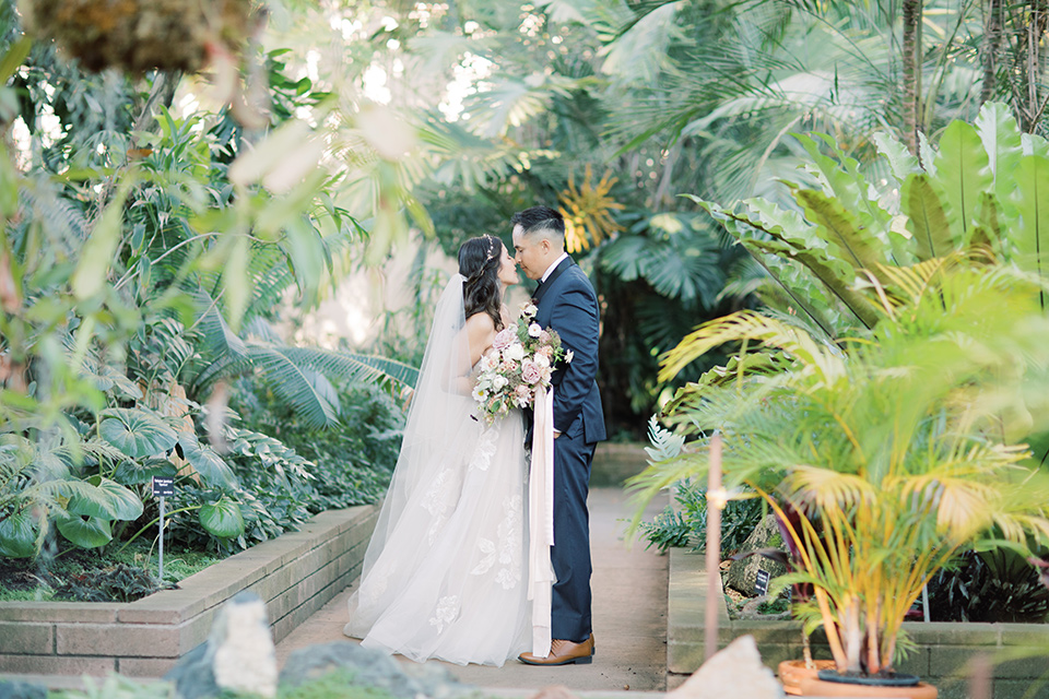  classic and modern balboa wedding with the groom in a navy shawl – couple by greenery