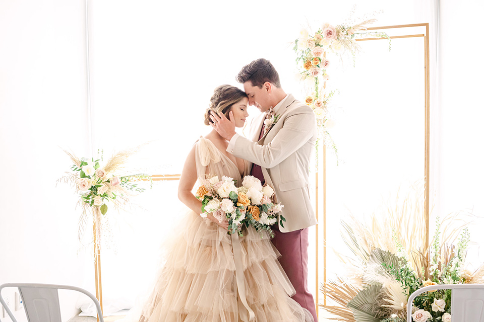  fun pink and champagne wedding with the bride in a pink tulle gown and the groom n a tan and pink look- couple at ceremony