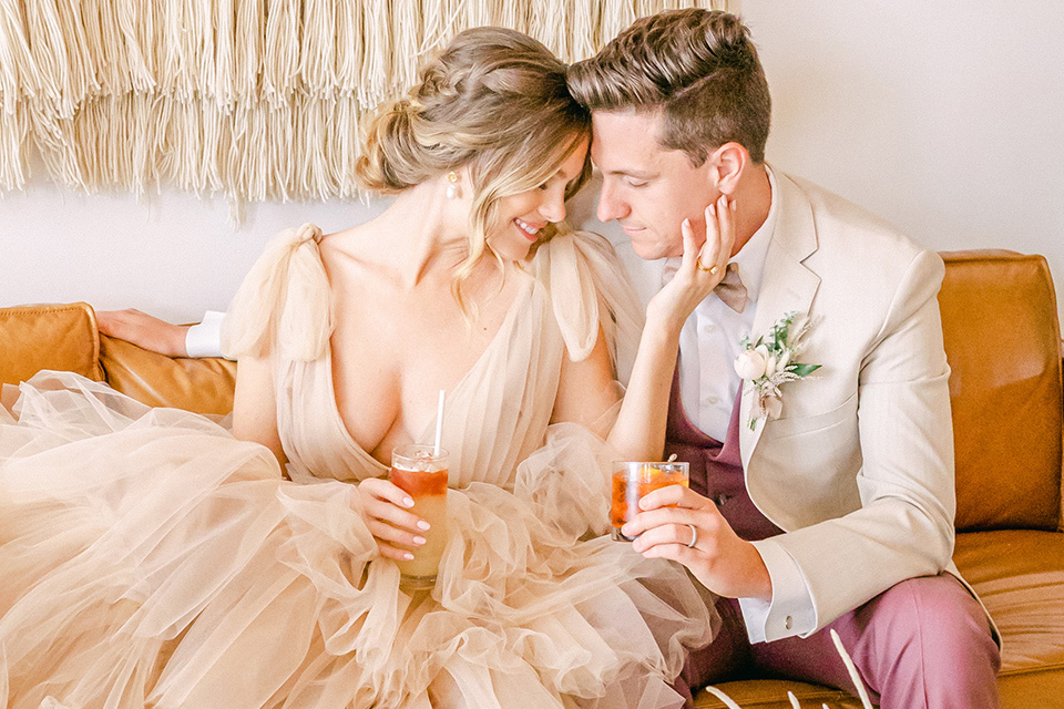  fun pink and champagne wedding with the bride in a pink tulle gown and the groom n a tan and pink look- couple on the couch
