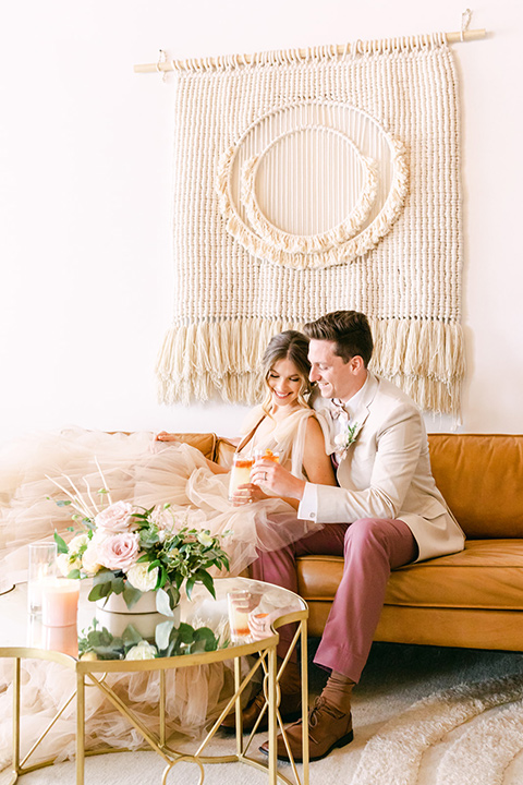  fun pink and champagne wedding with the bride in a pink tulle gown and the groom n a tan and pink look- couple sitting on the couch