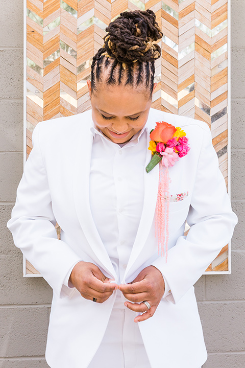  bright and bold lesbian wedding in Palm Springs with one bride in a rose pink suit and the other in a white suit – white suit