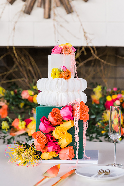  bright and bold lesbian wedding in Palm Springs with one bride in a rose pink suit and the other in a white suit – cake