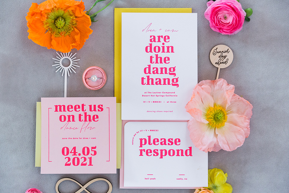  bright and bold lesbian wedding in Palm Springs with one bride in a rose pink suit and the other in a white suit – invitations