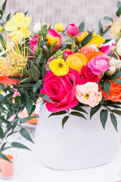  bright and bold lesbian wedding in Palm Springs with one bride in a rose pink suit and the other in a white suit – walking down the aisle