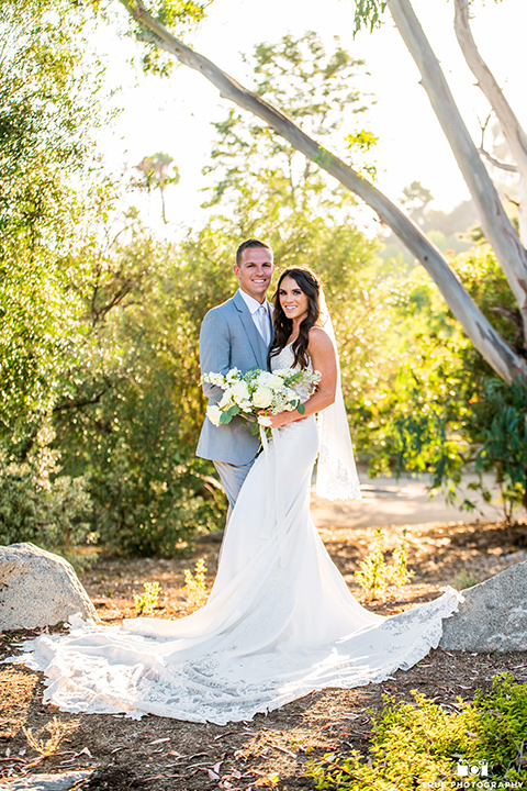  something blue inspired wedding with the bridesmaids in blue dresses the groomsmen in light blue suits and the bride in a lace gown – couple kissing