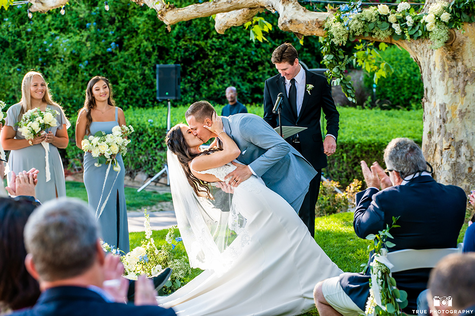  something blue inspired wedding with the bridesmaids in blue dresses the groomsmen in light blue suits and the bride in a lace gown – first kiss