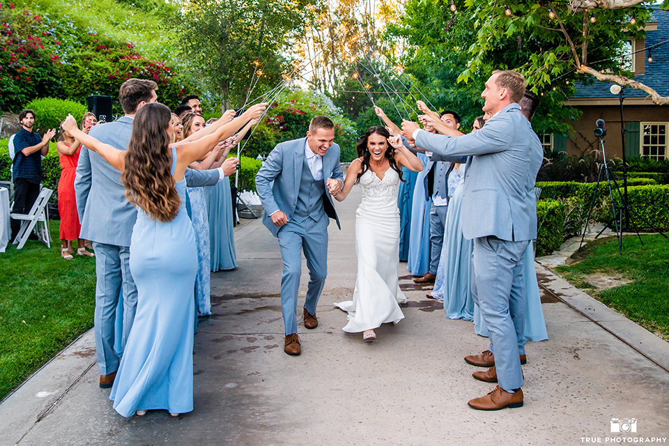  something blue inspired wedding with the bridesmaids in blue dresses the groomsmen in light blue suits and the bride in a lace gown – bridal party with sparklers