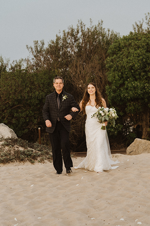  boho modern beach wedding on the sand – bride walking down the aisle