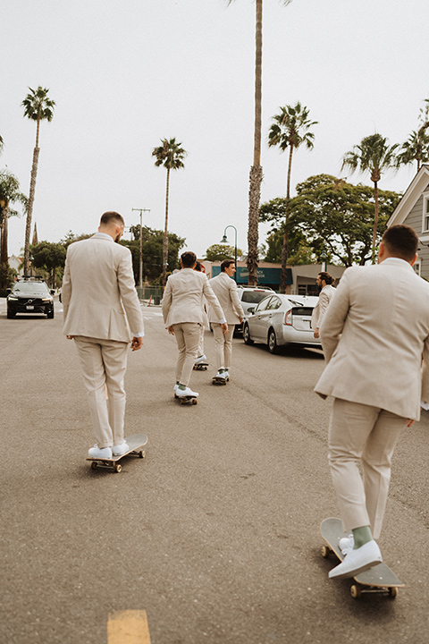  boho modern beach wedding on the sand – groomsmen skating 