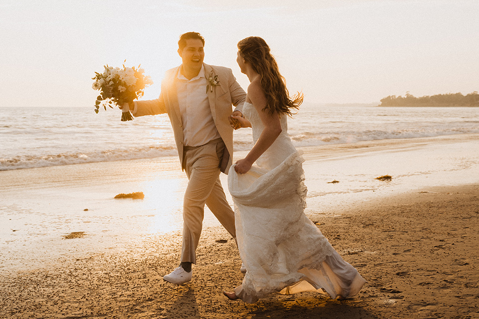  boho modern beach wedding on the sand – couple running on the sand