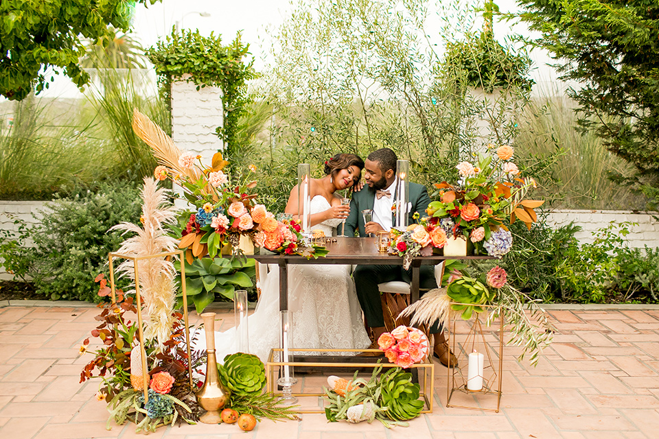  green and yellow casino san clemente wedding with the groom in a green suit – couple at table