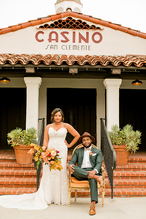  green and yellow casino san clemente wedding with the groom in a green suit – couple by the stairs