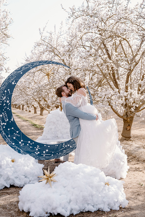  celestial cherry blossom wedding with the groom in a light blue coat and grey pants – couple at ceremony