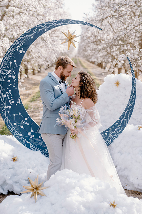  celestial cherry blossom wedding with the groom in a light blue coat and grey pants – couple at ceremony 
