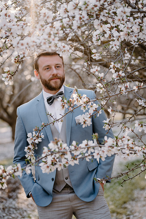 celestial cherry blossom wedding with the groom in a light blue coat and grey pants – groom 