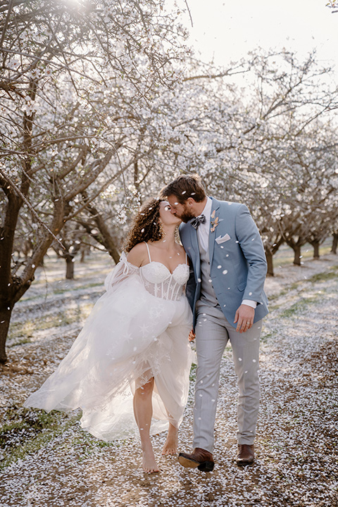  celestial cherry blossom wedding with the groom in a light blue coat and grey pants – couple at reception