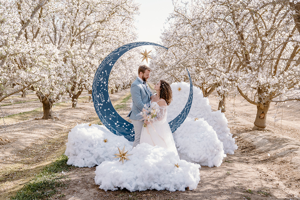  celestial cherry blossom wedding with the groom in a light blue coat and grey pants – couple at ceremony