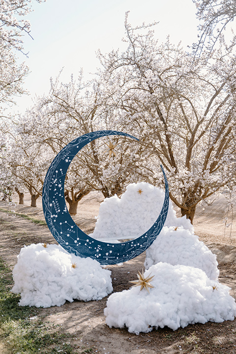  celestial cherry blossom wedding with the groom in a light blue coat and grey pants – altar