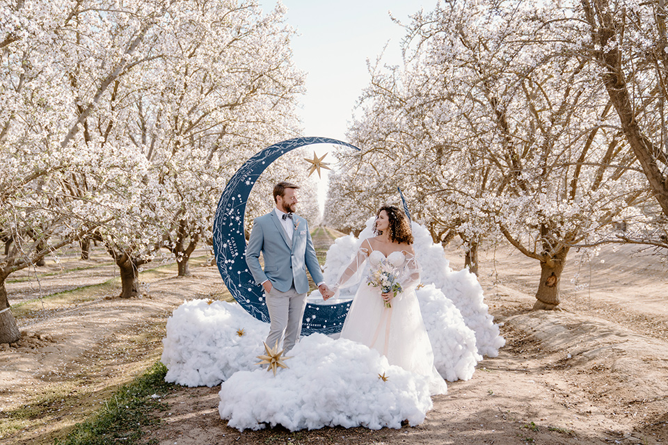  celestial cherry blossom wedding with the groom in a light blue coat and grey pants –coupe at ceremony