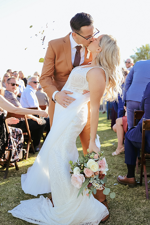  a groovy barn wedding with a neutral color palette and beer - couple walking down the aisle 