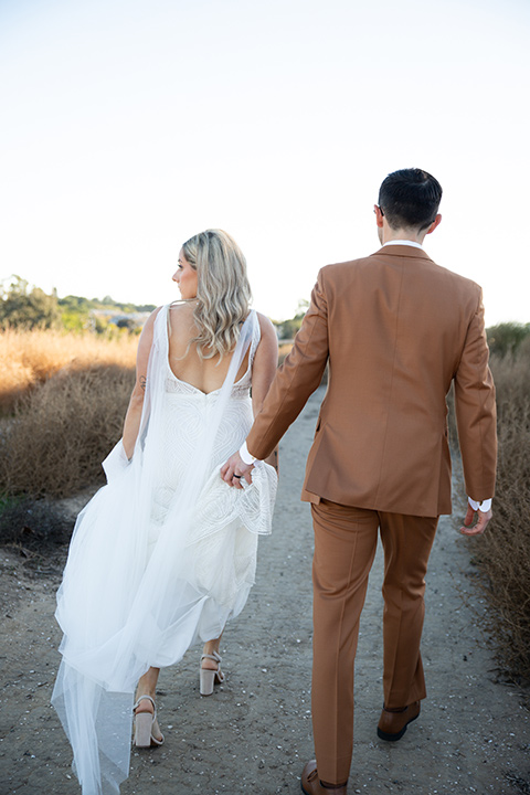  a groovy barn wedding with a neutral color palette and beer - couple walking 