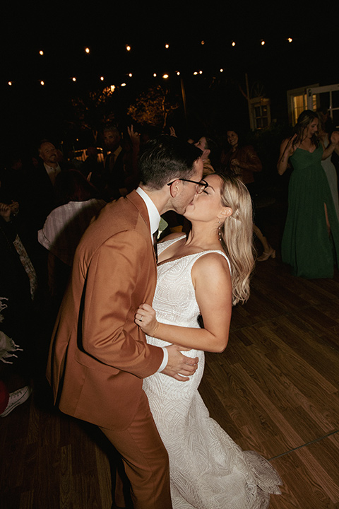  a groovy barn wedding with a neutral color palette and beer - kissing at reception 