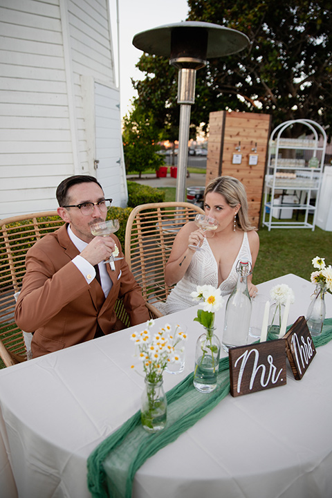  a groovy barn wedding with a neutral color palette and beer - couple at sweetheart table 