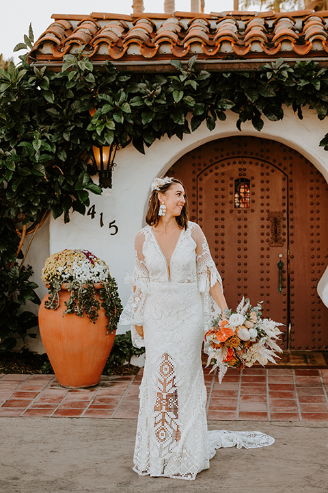  boho beach wedding with Spanish inspired architecture with the bride in a lace gown and the groom in a black tuxedo – bride 