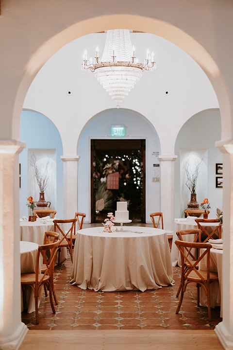  boho beach wedding with Spanish inspired architecture with the bride in a lace gown and the groom in a black tuxedo – cake + dessert table