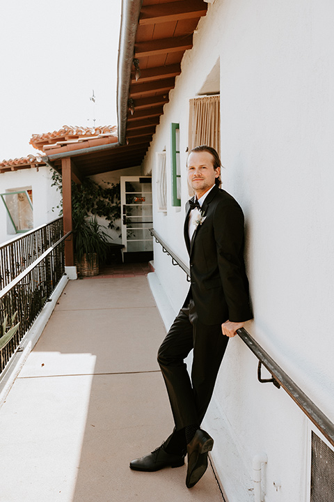  boho beach wedding with Spanish inspired architecture with the bride in a lace gown and the groom in a black tuxedo – groom 