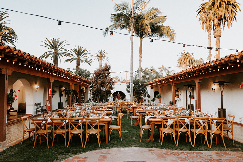  boho beach wedding with Spanish inspired architecture with the bride in a lace gown and the groom in a black tuxedo – reception space