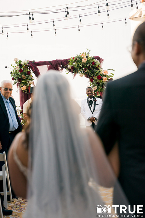  black and white beach wedding with lux details – bride walking down the aisle 