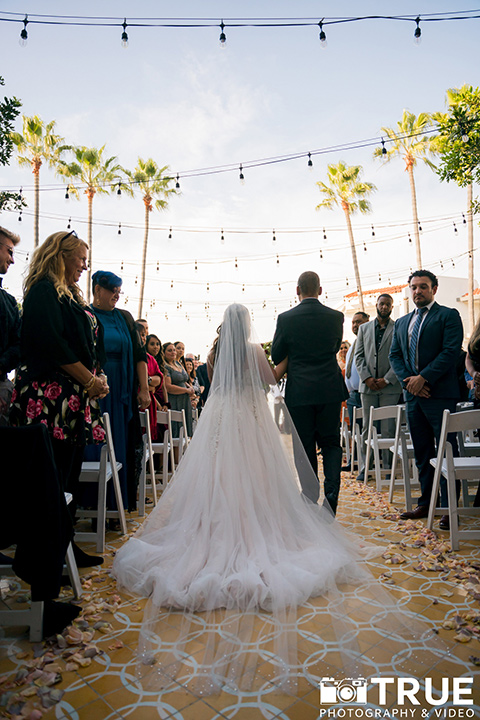  black and white beach wedding with lux details – bride walking down the aisle 