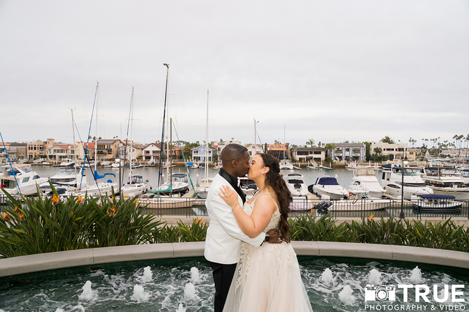  black and white beach wedding with lux details – kissing outside venue 