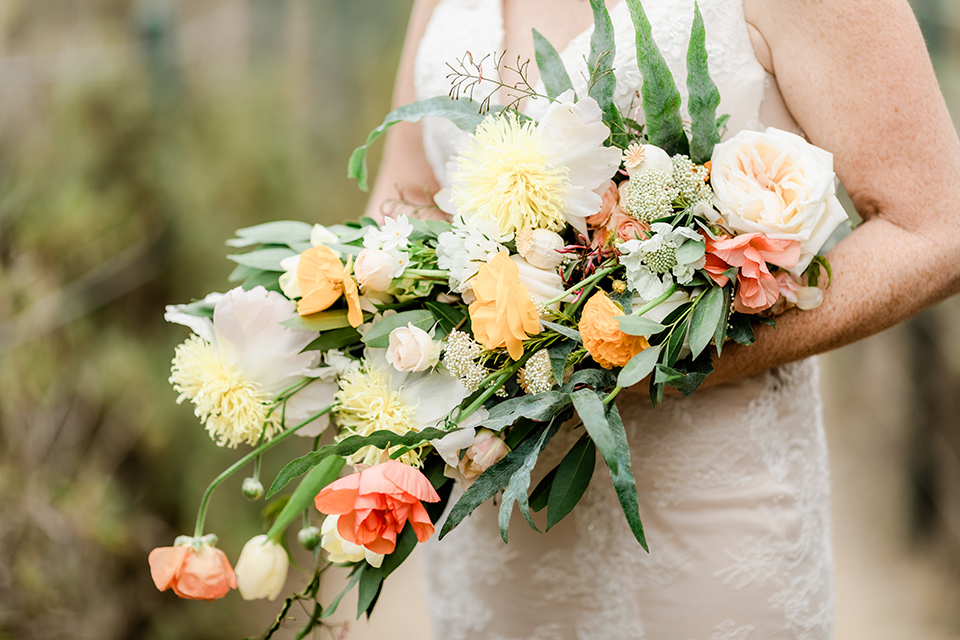  whimsical wedding at an ocean front venue with the groom in a mix and match look with navy and grey colors – bridal bouquet