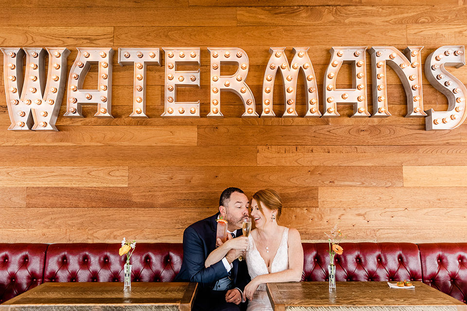  whimsical wedding at an ocean front venue with the groom in a mix and match look with navy and grey colors – couple at venue