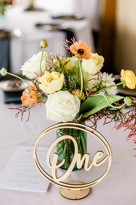  whimsical wedding at an ocean front venue with the groom in a mix and match look with navy and grey colors – table numbers